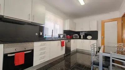 a kitchen with white cabinets and red towels at Apartamento Luar in Ribeira Brava