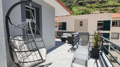 a hammock on the balcony of a house at Apartamento Luar in Ribeira Brava