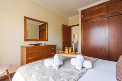 a bedroom with a bed with white pillows on it at Strelitzia Apartment by AH in Caniço