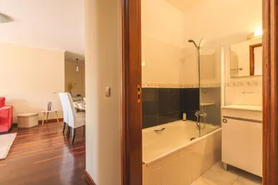 a bathroom with a bath tub and a sink at Strelitzia Apartment by AH in Caniço
