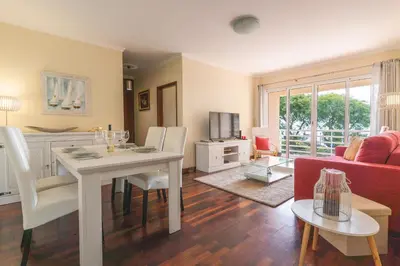 a living room with a table and a red couch at Strelitzia Apartment by AH in Caniço