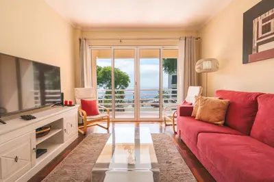 a living room with a red couch and a tv at Strelitzia Apartment by AH in Caniço