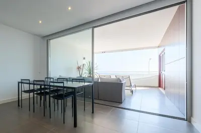 a dining room with a table and a couch at Beach Condominium 27 by Destination Algarve in Santo Amaro