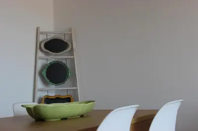a table with a green bowl on a table with a shelf at Mel Apartment in Funchal