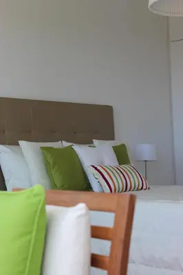 a bed with green and white pillows on it at Mel Apartment in Funchal