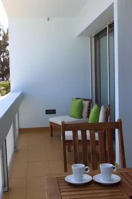 a balcony with a bench and a table with two cups at Mel Apartment in Funchal