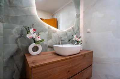 a bathroom with a sink and flowers on a wooden counter at BravaSol by LovelyStay in Tábua