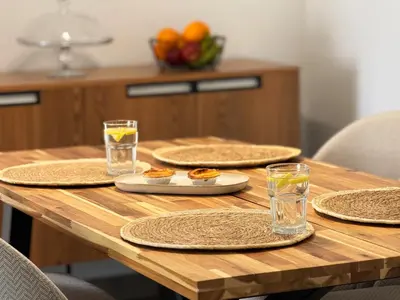 a wooden table with plates of food and glasses of water at 10 min to Calheta Beach - Apartamento Da Natureza - KING Size Bed - LARGE Terrace in Arco da Calheta