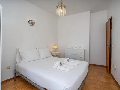 a bedroom with a white bed and a chandelier at Traditional house by the beach #1979 in Luz