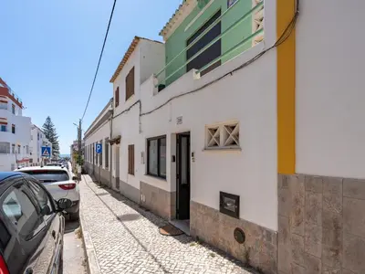 a building on a street with cars parked next to it at Traditional house by the beach #1979 in Luz