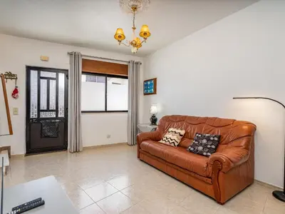 a living room with a brown leather couch and a window at Traditional house by the beach #1979 in Luz