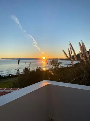 a sunset over the ocean from a balcony of a house at A casa da Xã in Almagreira