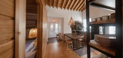 a kitchen and dining room with a table and chairs at AZORINSITU - Casas da Ribeira in Vila do Porto
