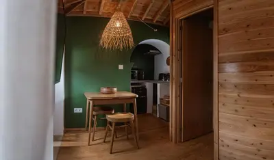 a kitchen with a small table and a chandelier at AZORINSITU - Casas da Ribeira in Vila do Porto
