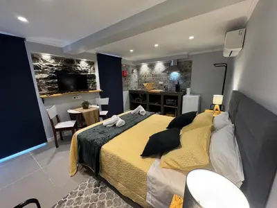 a bedroom with a large bed with red rugs at Refúgio do Nevoeiro Estudio in Porto Moniz