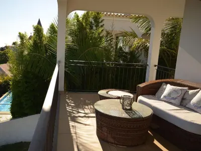 a patio with a couch and a table on a porch at Villa 17°West with Pool in Estreito da Calheta