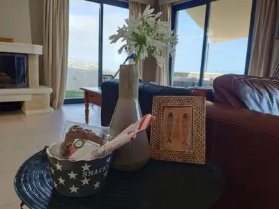 a living room with a table with a vase and a picture at Villa 17°West with Pool in Estreito da Calheta