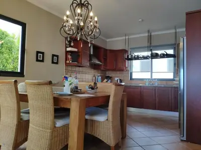 a kitchen with a wooden table and chairs at Villa 17°West with Pool in Estreito da Calheta