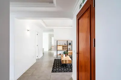 a hallway with white walls and a wooden door at Quinta dos Louros in Estreito da Calheta