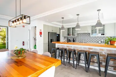 a kitchen with a wooden table and chairs at Quinta dos Louros in Estreito da Calheta
