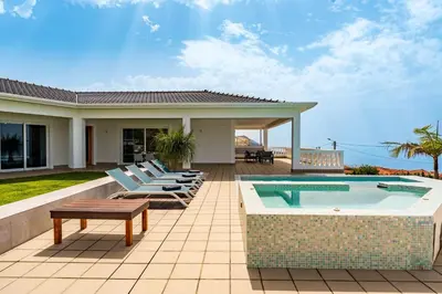 a backyard with a swimming pool and a house at Quinta dos Louros in Estreito da Calheta