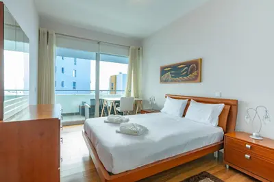 a bedroom with a large bed and a balcony at Alameda in Funchal