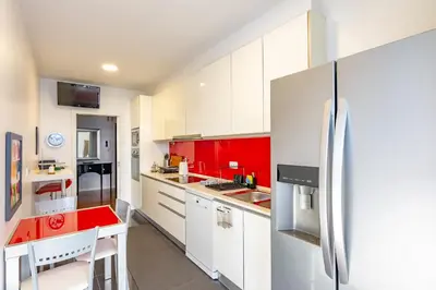 a kitchen with red and white cabinets and a refrigerator at Alameda in Funchal