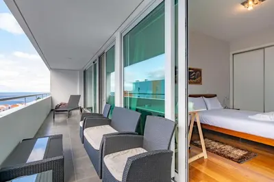 a bedroom with a bed and a desk and chairs at Alameda in Funchal