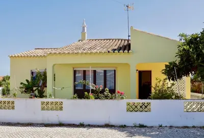 a yellow house with a white fence at Casa do Afonso in Sagres