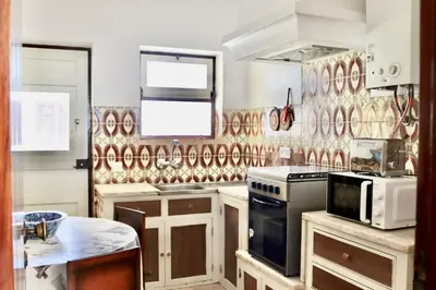 a kitchen with a stove and a microwave at Casa do Afonso in Sagres