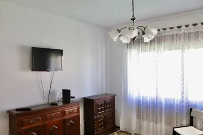 a room with a tv and a dresser and a window at Casa do Afonso in Sagres