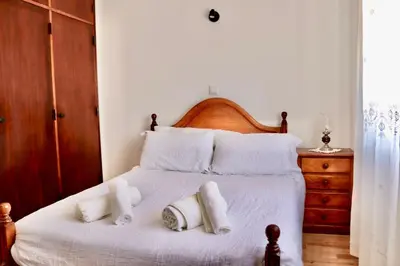a bedroom with a bed with white sheets and pillows at Casa do Afonso in Sagres