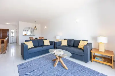 a living room with two blue couches and a table at Casa da Praia da Luz T2 plus 1 in Luz