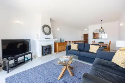 a living room with a blue couch and a tv at Casa da Praia da Luz T2 plus 1 in Luz