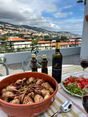 a table with a bowl of food and a bottle of wine at Starry View in Funchal