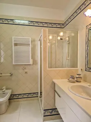 a white bathroom with a sink and a toilet at L'Oasis Palm Beach House in Porto Santo