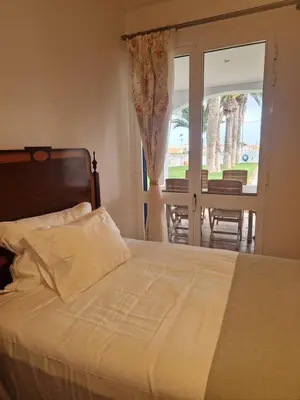 a bedroom with a bed and a view of a patio at L'Oasis Palm Beach House in Porto Santo