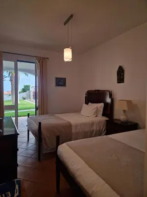 a hotel room with two beds and a balcony at L'Oasis Palm Beach House in Porto Santo