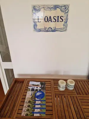 a table with plates and a sign on a wall at L'Oasis Palm Beach House in Porto Santo