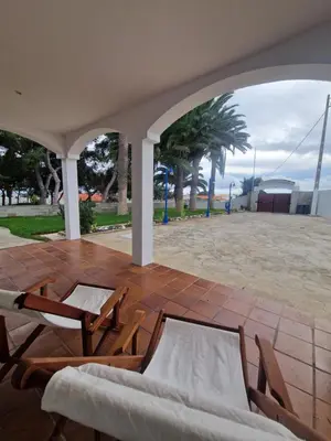 a patio with two chairs and a table at L'Oasis Palm Beach House in Porto Santo