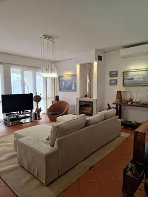 a living room with a couch and a television at L'Oasis Palm Beach House in Porto Santo