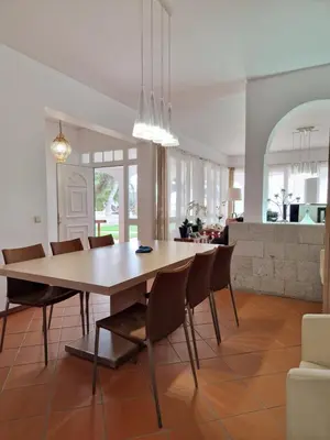 a dining room and living room with a table and chairs at L'Oasis Palm Beach House in Porto Santo