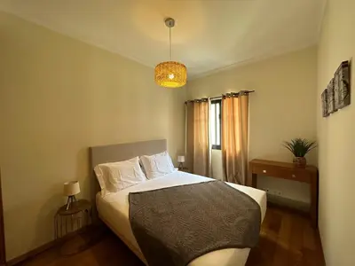 a bedroom with a bed and a chandelier at Apartamentos da Carreira in Funchal