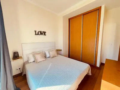 a bedroom with a bed with a love sign on the wall at Apartamentos da Carreira in Funchal