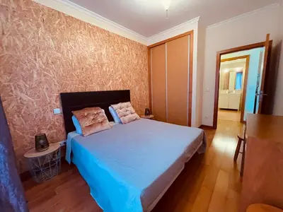 a bedroom with a large bed with blue sheets at Apartamentos da Carreira in Funchal