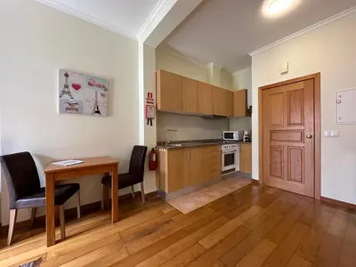 a kitchen with a table and chairs and a dining room at Apartamentos da Carreira in Funchal