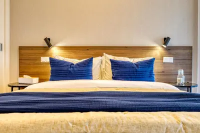 a bedroom with a large bed with blue pillows at Funchal Acqua Blue 5L, a Home in Madeira in Funchal