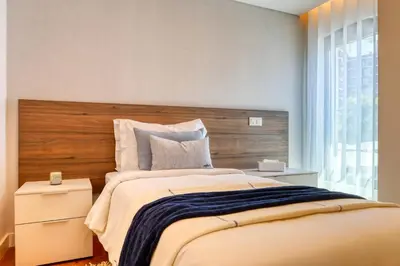a bedroom with a large bed with a wooden headboard at Funchal Acqua Blue 5L, a Home in Madeira in Funchal