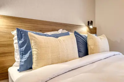 a bed with blue and white pillows on it at Funchal Acqua Blue 5L, a Home in Madeira in Funchal