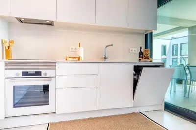 a kitchen with white cabinets and a sink at Funchal Acqua Blue 5L, a Home in Madeira in Funchal